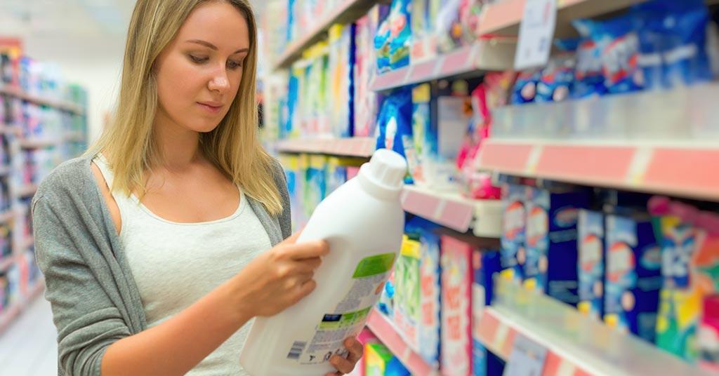 woman checking household cleaner for chemicals