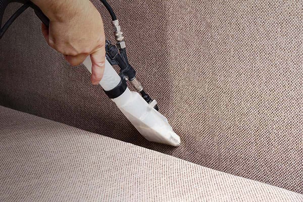 Steam cleaning the fabric using an emulsion cleaner.